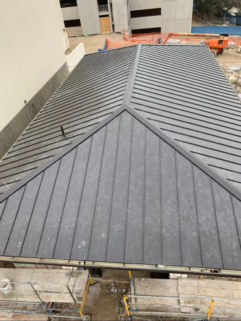 Commercial metal roof construction with crane equipment in Paramount